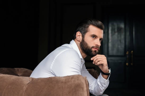istock thoughtful handsome bearded man sitting in armchair 927817924