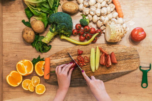 istock Young woman cutting vegetables 927818694