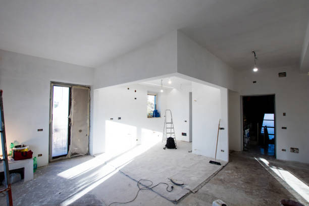 Apartment under renovation with building material and building dust. Plaster carton and test lighting, windows with cardboard and electric wires to be covered. stock photo