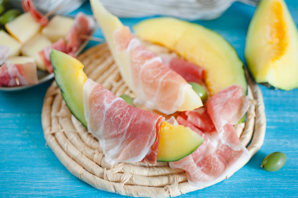 istock Cantaloupe melon, italian ham slices and olives 927825864