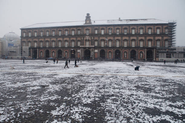 Naples, Piazza Plebiscito, with Snow Naples, Italy - Feb 27, 2018: Main square in the city of Naples called "piazza Plebiscito" with snow and people walking around and playing with snow. Royal Palace facade in background. Photo taken at morning during a very unusual event like this snowfall. Latest snowfall in Piazza Plebiscito was in 1956. piazza plebiscito stock pictures, royalty-free photos & images