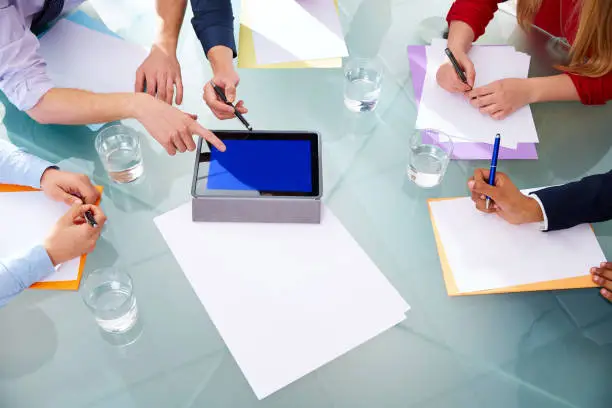 Business meeting teamwork aerial table view with hands papers and touch pad at office