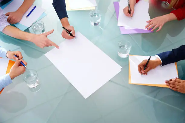 Business meeting teamwork aerial table view with hands pen and papers at office