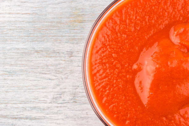 istock glass cup with tomato paste on a wooden background - close-up, top view 927833966
