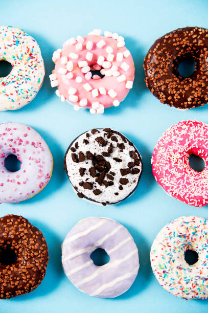 istock Various donuts on a colorful background. Top view shot. Sweetness, happiness conception. 927845118