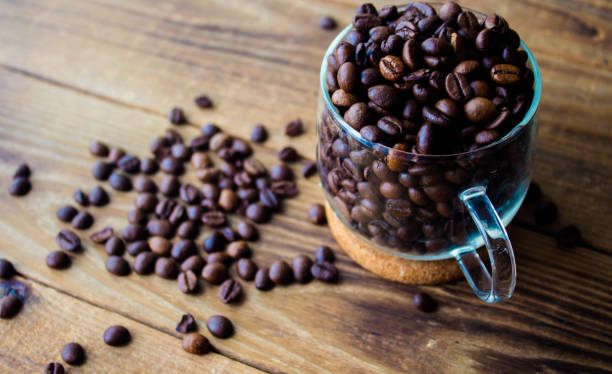 чашка бобов кофе на деревянном фоне - coffeetree стоковые фото и изображения