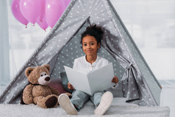 istock african american kid holding book and looking at camera 927845538