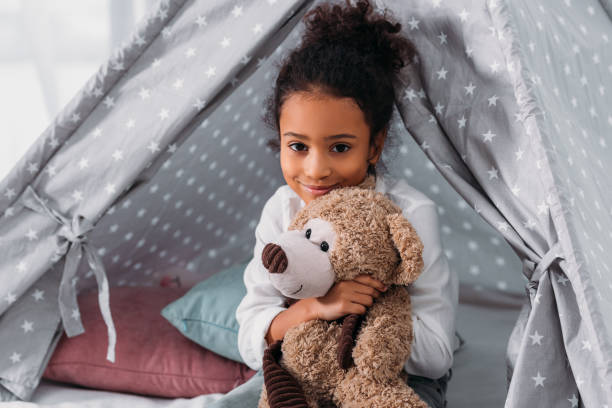istock african american kid hugging teddy bear and looking at camera 927848590