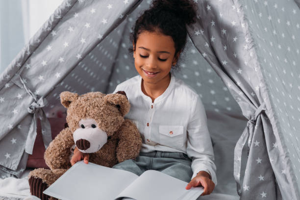 istock african american kid reading book and hugging teddy bear 927848864