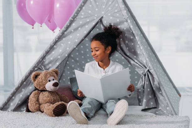 istock african american kid reading book to teddy bear 927849022