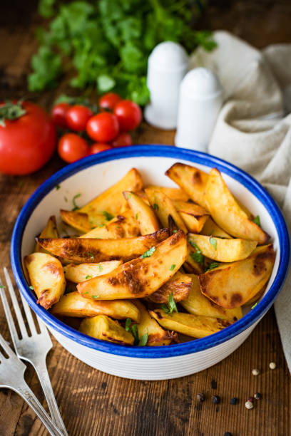 quartiers de pommes de terre rôties dans un bol de dîner - prepared potato oven roasted potatoes roasted photos et images de collection