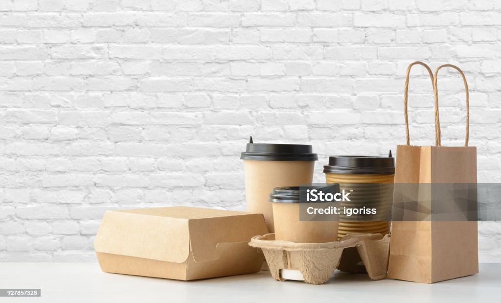 Fast food and drink packaging set Fast food packaging set. Paper coffee cups in holder, food box, brown paper bag on the table Take Out Food Stock Photo