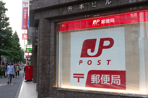 Tokyo, Japan - May 28, 2016 : People walk past the Post Office in Shinjuku, Tokyo, Japan. Japan Post offering postal and package delivery services, banking services and life insurance.