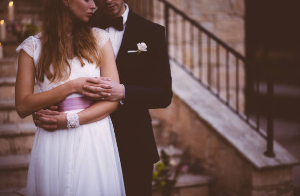 istock Newlywed bride and groom embracing at rustic cottage wedding reception 927859798