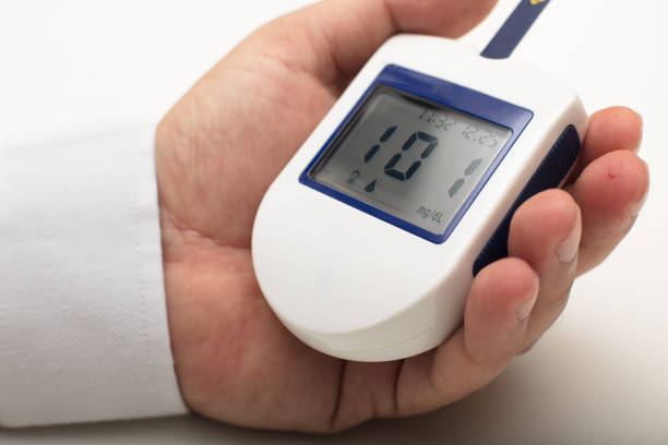 istock Man holding a portable digital glucose meter 927860824