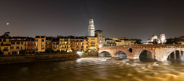 Riverside view of the Adige River from ponte di castelvecchio bridge built in 1350s with arches. Verona cityscape