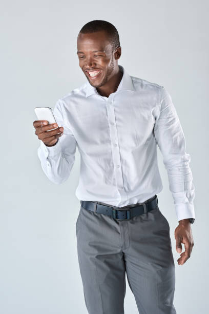 istock Formally dressed African business professional looking at his mobile device 927868466