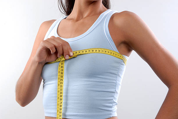 Slim woman measuring breast stock photo