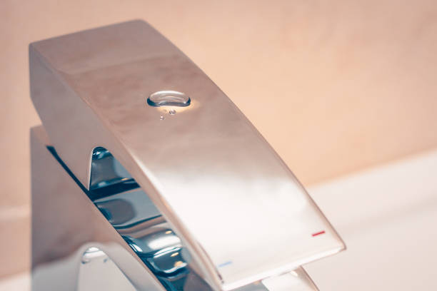 istock Glossy smooth chrome-plated surface mixer with a drop of water in the bathroom, saving water 927876912