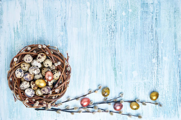 istock Easter willow wreath and colorful Easter eggs on light blue background. Top view, copy space 927879790