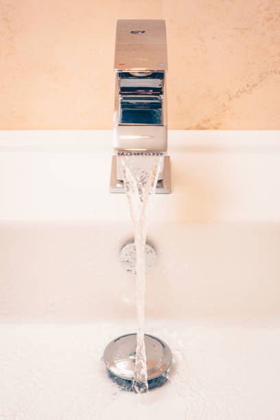 Smooth water jet from an expensive premium chrome mixer in the bathroom Smooth water jet from an expensive premium chrome mixer in the bathroom jetting stock pictures, royalty-free photos & images