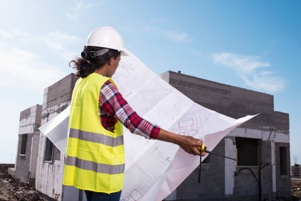 istock Civil engineer woman examining blueprint. 927884104