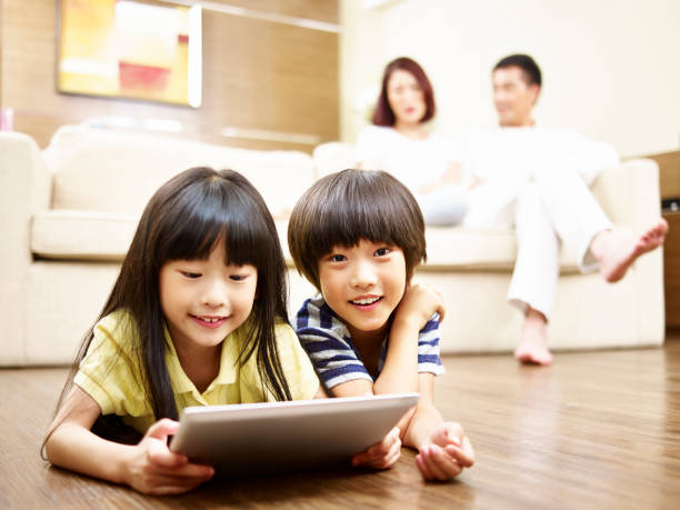 階デジタル タブレットで遊ぶ 2 人のアジア子供 - digital tablet looking child offspring ストックフォトと画像