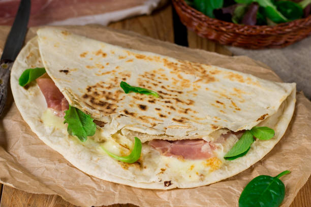 istock Italian flatbread piadina with prosciutto ham and mozzarella cheese 927888552