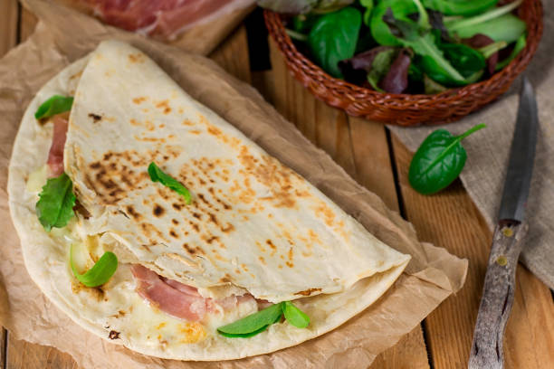 istock Italian flatbread piadina with prosciutto ham and mozzarella cheese 927888572