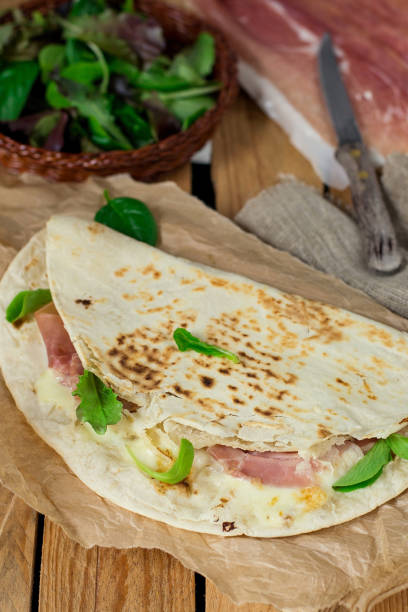 istock Italian flatbread piadina with prosciutto ham and mozzarella cheese 927888584