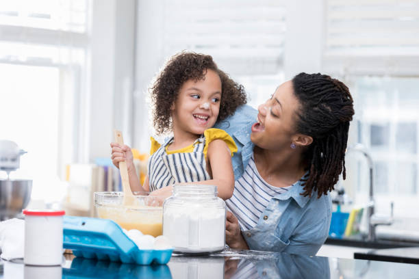 istock Mother and young daughter tease each other while baking together 927892100