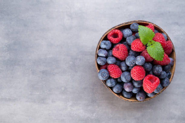 istock Juicy and fresh blueberries with green mint on rustic gray table. 927900508