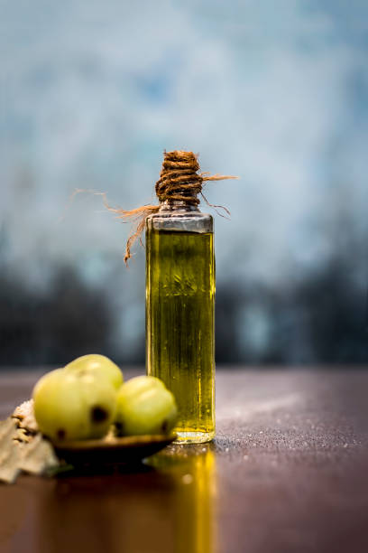 Raw fresh ripe Phyllanthus emblica,amla or Indian gooseberry with its powder and extracted oil on wooden surface. Raw fresh ripe Phyllanthus emblica,amla or Indian gooseberry with its powder and extracted oil on wooden surface. unconventional wisdom stock pictures, royalty-free photos & images