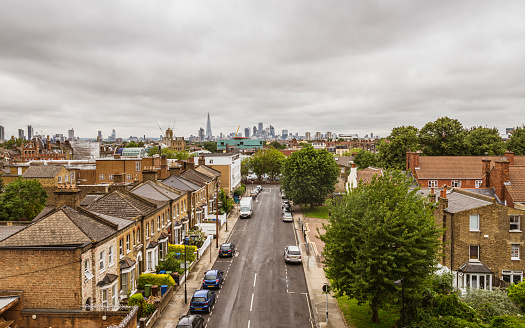 Elevated view of a Peckham street with residential housing and the city skyline with skyscrapers on the horizon.