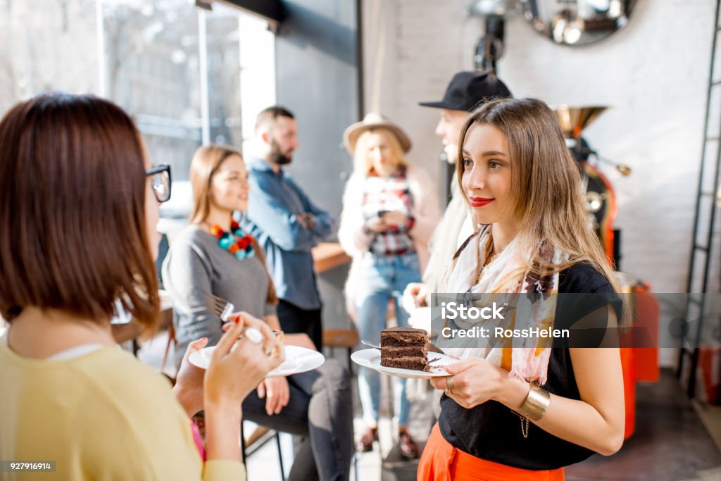 Friends in the cafe Young friends dressed casually have fun spending time in the beautiful cafe Networking Stock Photo