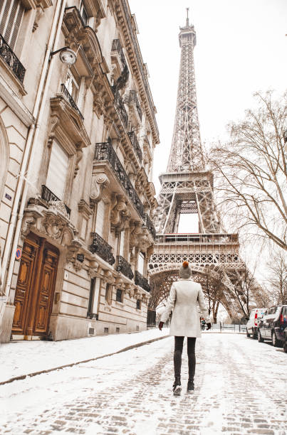 istock Woman walking to the Eiffel tower with snow 927923678