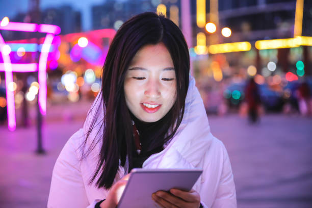 istock Young woman using digital tablet at night in the city 927923972