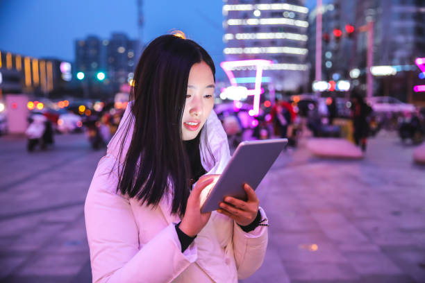 istock Young woman using digital tablet at night in the city 927924250