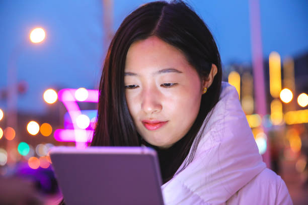 istock Young woman using digital tablet at night in the city 927924356