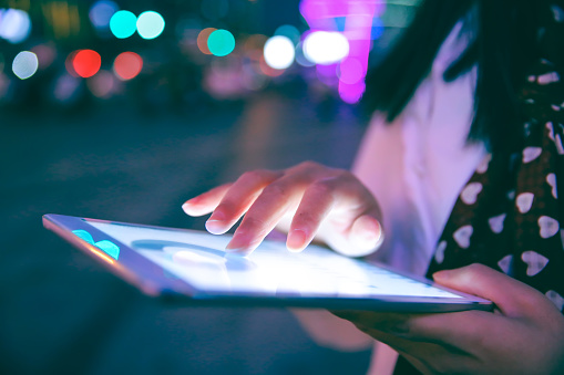 Mano con tableta digital en la noche photo