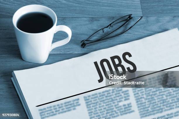 Cup Of Coffee Reading Glasses And A Newspaper With Job Advertisements During A Job Search Stock Photo - Download Image Now