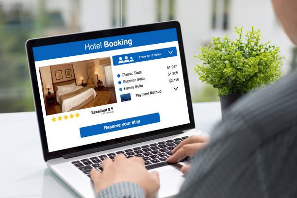 istock Man holding computer with app hotel booking screen in cafe 927938594
