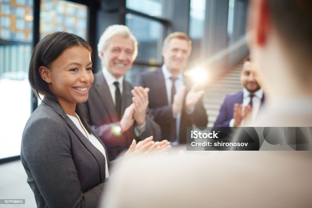 Greeting winner Happy female politician and her colleagues greeting speaker with ovations and congratulating him on victory Government Stock Photo