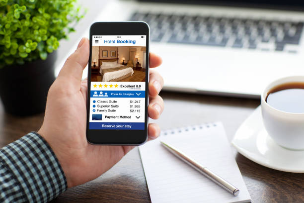 istock man holding phone with app hotel booking screen in office 927940076