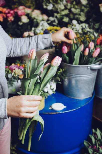 istock Modern florist working with flowers in workshop - with detail on hands 927949546