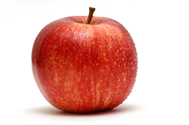 apple covered in water droplets against white