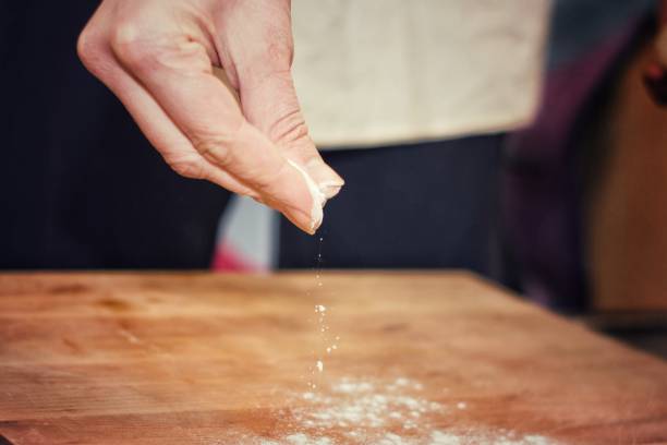 istock Chef pouring flour on wooden board.Selective focus. 927958240