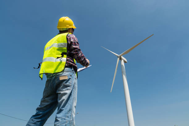 istock Electric Engineer writing report on Clipboard with Wind turbine power Generator 927958960