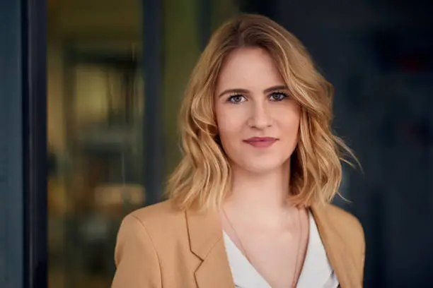 Portrait of smart elegant woman standing against dark background