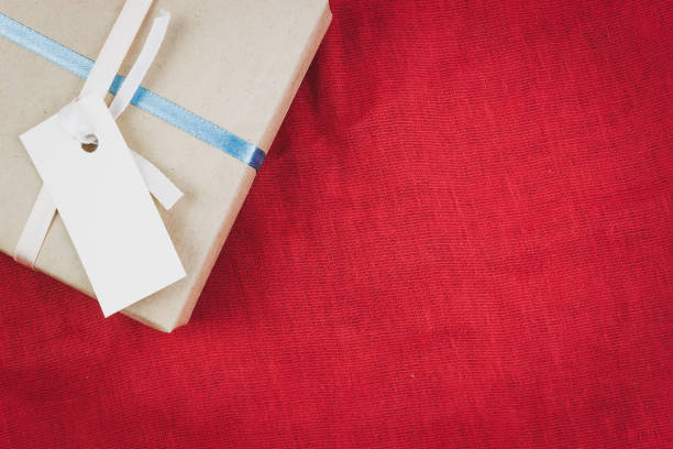 istock Gift box of Kraft paper on a red background 927976216